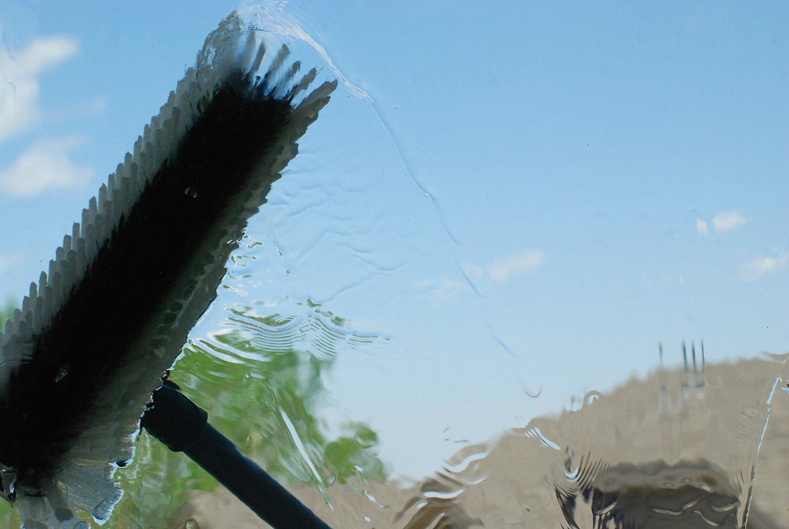 Close-up of a squeegee pass leaving streak-free glass